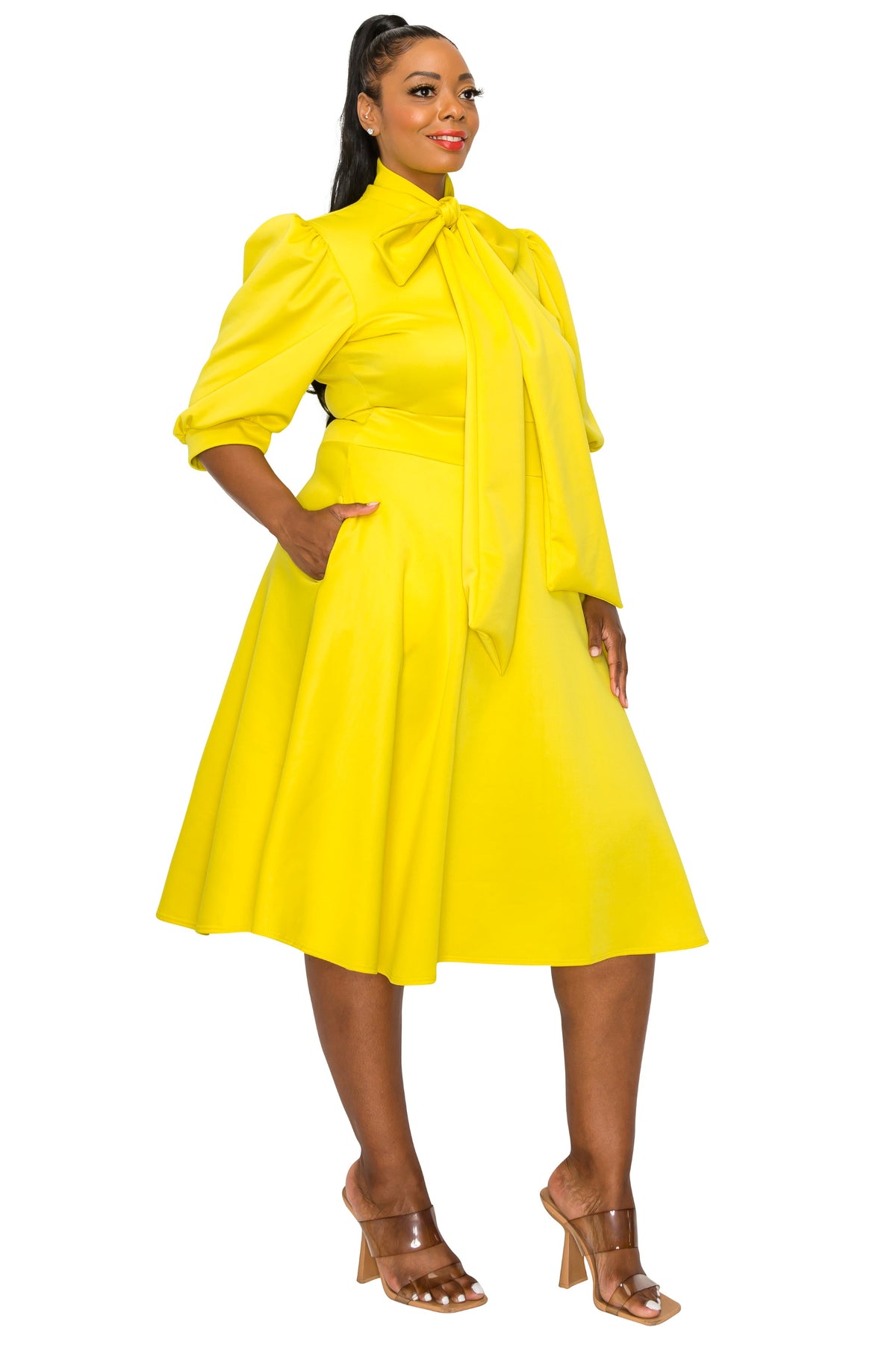 yellow plus size flair dress. midi length,  hands in pockets. side view