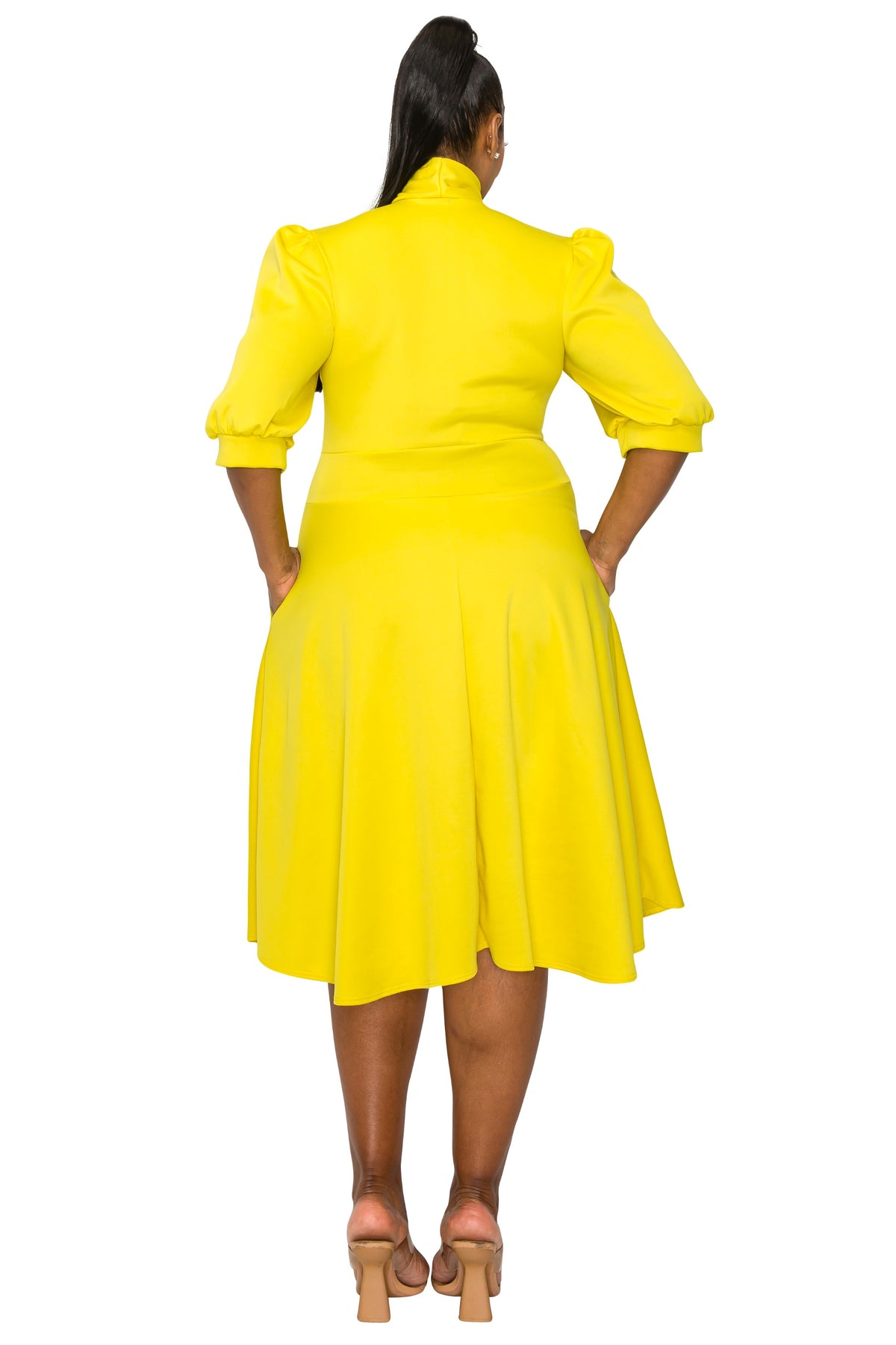 yellow plus size flair dress. midi length,  hands in pockets. back view