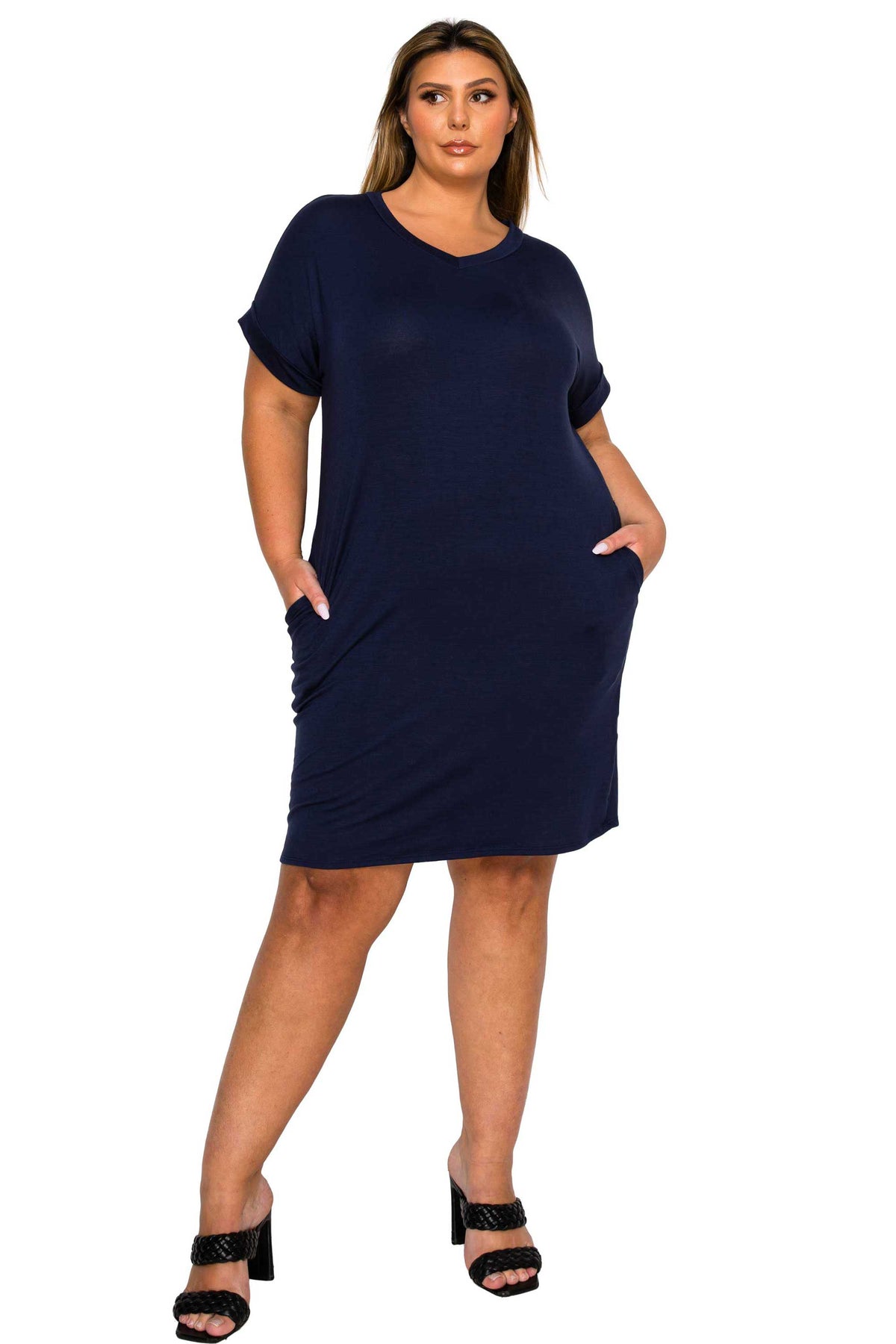 pink color casual plus size dress. short sleeves knee length with plus size models hands in pockets. front view