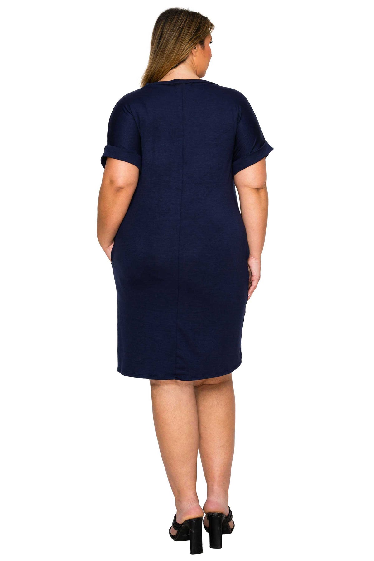 navy color casual plus size dress. short sleeves knee length with plus size models hands in pockets. back view
