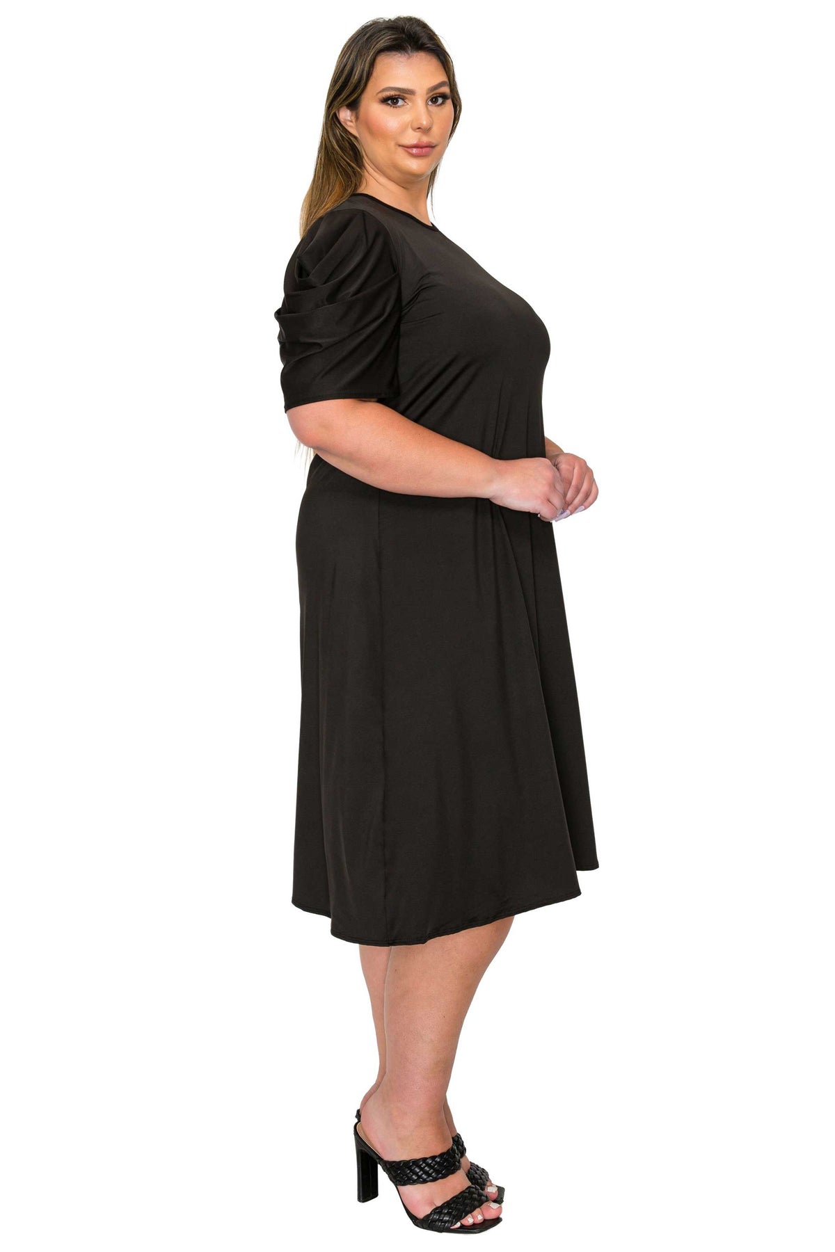 black color plus size dress, side view of model. gathered shoulders and midi flare hem