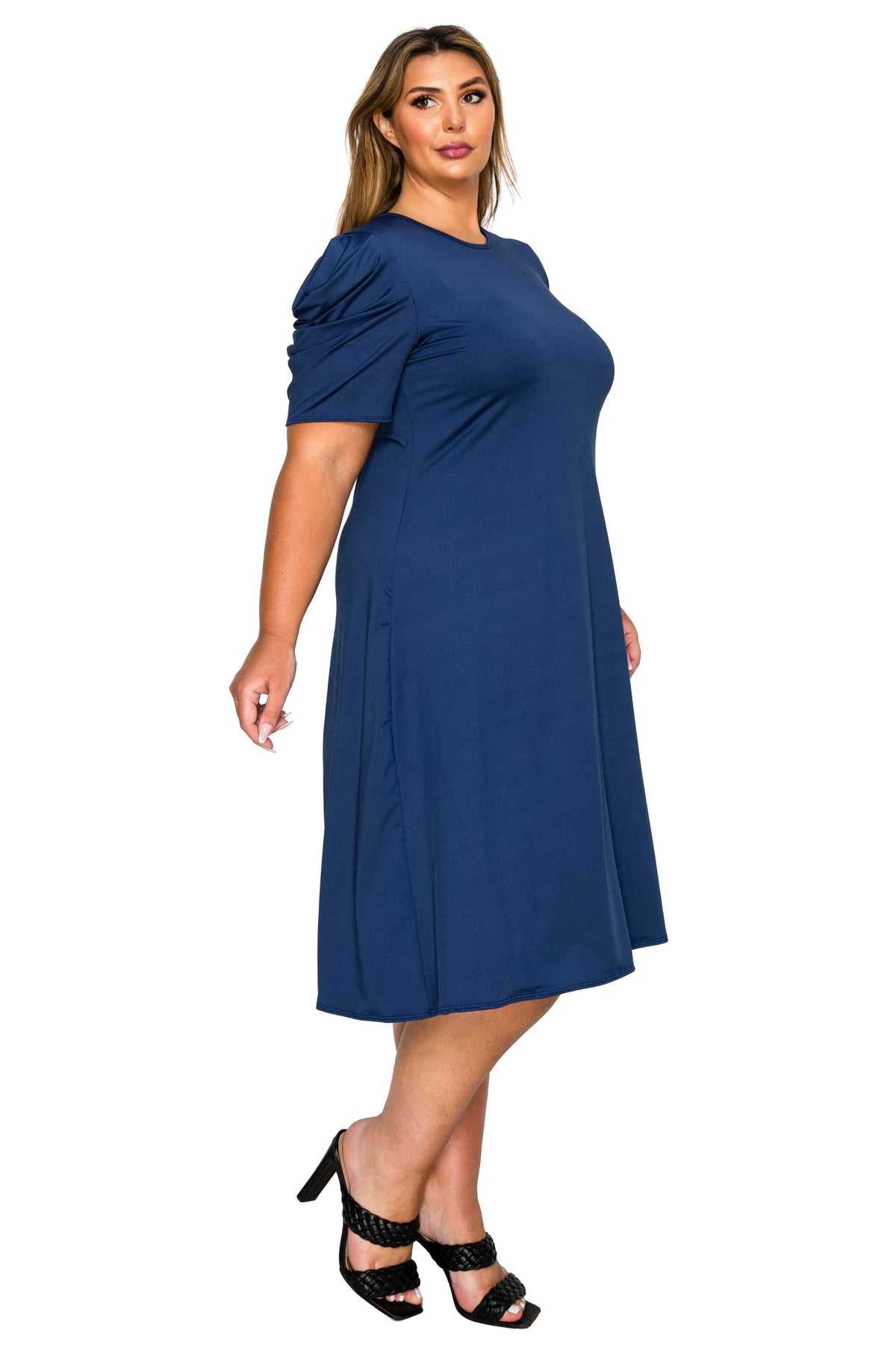 navy color plus size dress, side view of model. gathered shoulders and midi flare hem